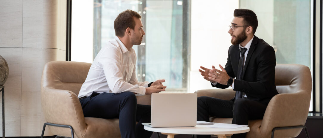 Middle eastern and caucasian ethnicity businessmen talking negotiating indoors